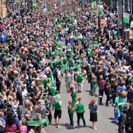 imagen de mucha gente en la calle vestida de verde celebrando San Patricio