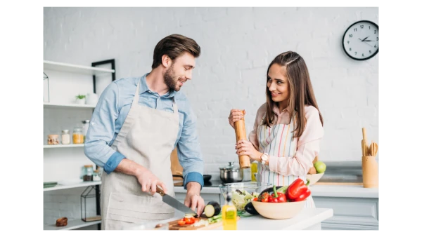 imagen de un hombre y una mujer haciendo la cena en la cocina