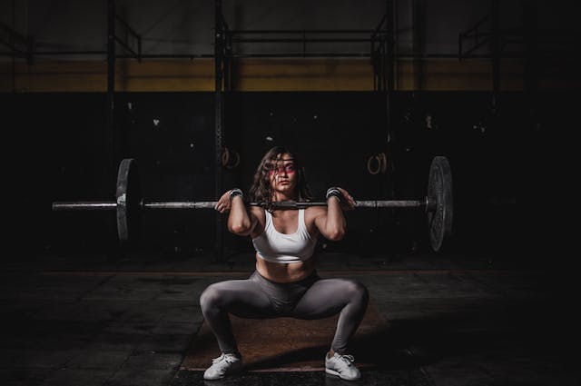 imagen de una mujer levantando pesas en un gimnasio